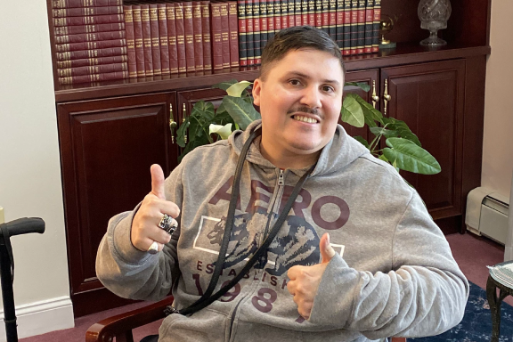 Man sitting in a chair giving two thumbs up